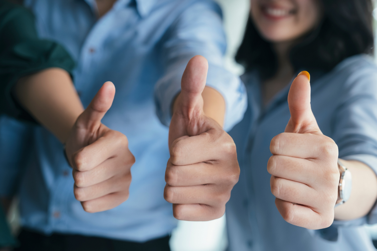 group of people showing thumbs up for quality customer service