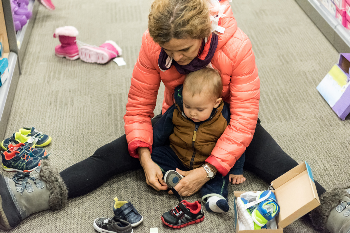 mature woman shopping for shoes for her baby boy